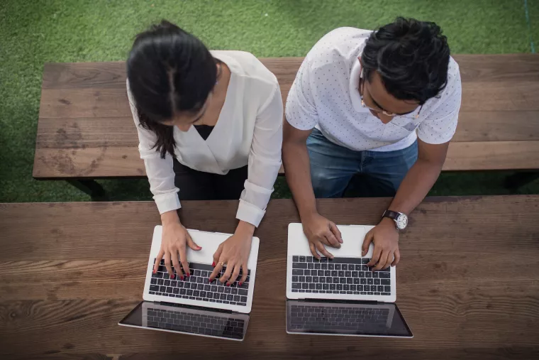 Two people using laptops